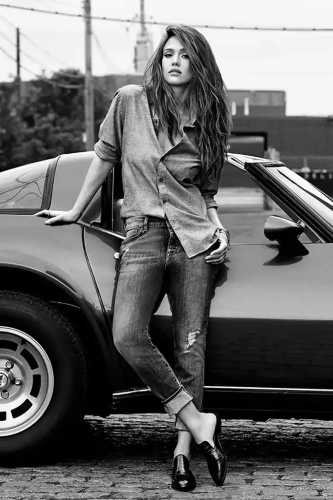 A woman leaning on a car